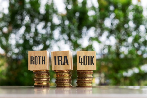 The terms Roth, IRA and 401K sit on top of stacks of coins